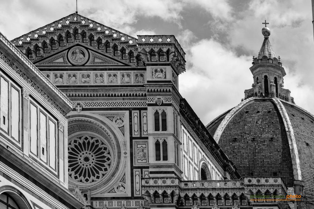 Detail of the Florence Cathedral, featuring the ornate Baptistery and the iconic dome, captured in black and white.